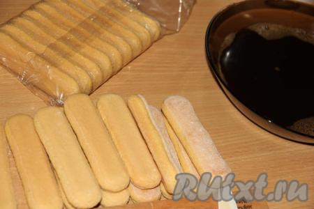 Перелить кофе в удобную миску. Обмакивать печенье "Дамские пальчики" в кофе и выкладывать в форму, в которой будете формировать десерт.