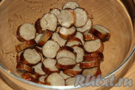 Переложить нарезанные баварские колбаски в салатник.