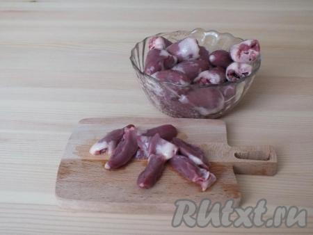 Куриные сердечки вымойте под проточной водой, отрежьте лишний жир. Разрежьте каждое сердечко на 4 части. Еще раз промойте, вымывая сгустки крови.