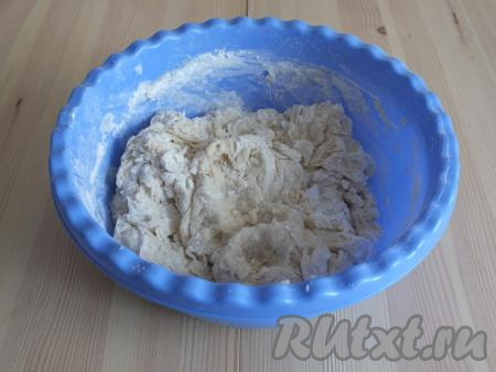 Далее вводите муку частями. Постепенное введение муки необходимо для того, чтобы тесто получилось воздушным. Насыпьте пару-тройку столовых ложек, размешайте. Когда тесто станет трудно перемешивать ложкой, добавьте оставшиеся 25 мл растительного масла и замешивайте руками. Тесто получится мягким, не липнущим к рукам.