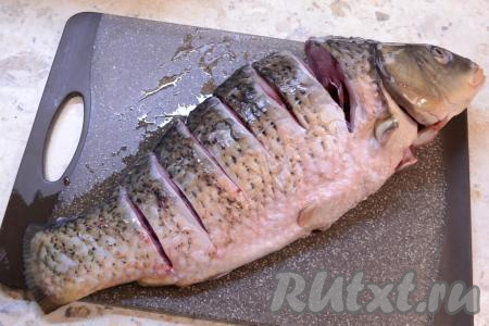 Карпа очистить от чешуи и внутренностей, удалить жабры. Рыбу хорошо вымыть и сделать 6-7 глубоких разрезов по спинке (это облегчит деление карпа на порции после приготовления).