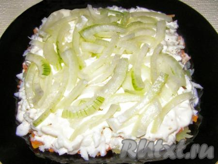 Очищаем и нарезаем полукольцами лук, обдаём кипятком. Выкладываем половину лука на слой белков, смазываем майонезом.