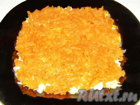Отваренную и остывшую морковь тоже натираем на крупной тёрке. Половину натёртой моркови выкладываем на картофель, разравниваем и смазываем майонезом.