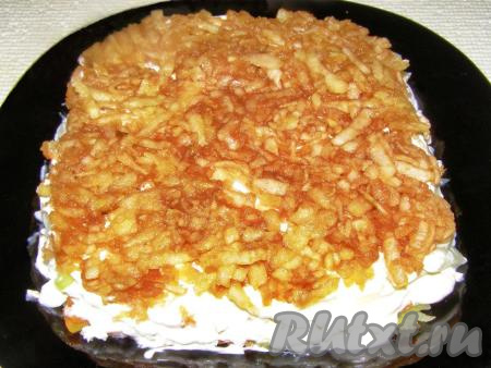 Следующий слой - половина натёртых на крупной тёрке яблок, предварительно очищенных от кожуры. Яблоки тоже смазываем майонезом.