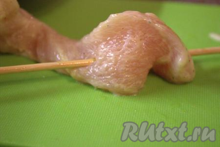 Достать шпажки из воды и нанизать куриное филе, замаринованное в кефире, на шпажки, как бы делая "стежки" (как на фото).