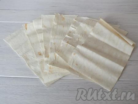Пока остывает крем, подготовьте коржи для торта. Разверните рулон лаваша. Сверните так, чтобы у вас получились прямоугольные листы (ориентировочно размер листа 25 на 15 см) и разрежьте. В этот раз у меня получилось 8 заготовок, но вы можете сделать и 10 штук.