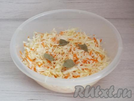 Морковь добавьте к капусте, перемешайте. Перетирать и жать овощи не нужно! Добавьте соль, разломанный на несколько кусочков лавровый лист, опять перемешайте.