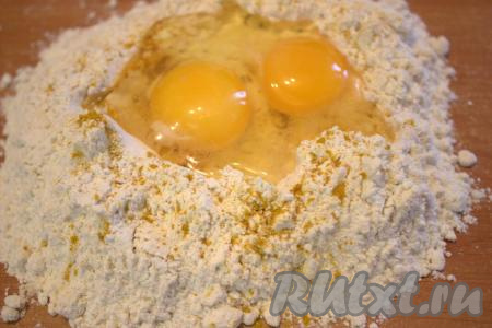 Вначале замесим тесто, для этого на рабочую поверхность нужно высыпать муку, добавить куркуму и щепотку соли. Сделать углубление в муке и вбить яйца.