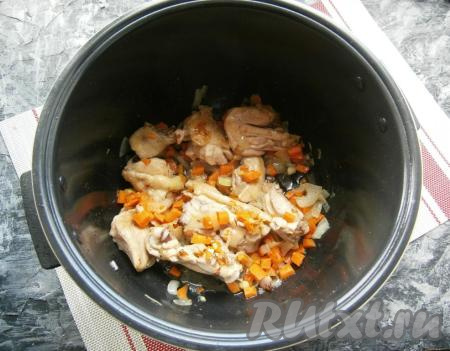 Выставить на 20 минут режим "Обжаривание". Периодически перемешивая кусочки курицы, готовить их 10 минут. Лук нарезать произвольно, морковь - небольшими кубиками, добавить их в чашу мультиварки, перемешать и обжаривать, иногда помешивая, 5&nbsp;минут.