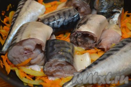 Лук и морковку выложить на сковороду с растительным маслом и обжарить овощи, иногда помешивая на среднем огне, до прозрачности лука и мягкости моркови (около 7-10 минут). Овощи не должны стать полностью готовыми, достаточно будет довести их до полуготовности. Посолить овощи по вкусу, можно добавить 1-2 столовые ложки воды, если овощная зажарка будет суховата. Затем поверх обжаренных овощей выложить кусочки скумбрии, уменьшить огонь до минимума, накрыть сковороду крышкой и тушить рыбу минут 10. На этом этапе перемешивать рыбку с овощами не нужно, пусть она протушится на овощной подушке.