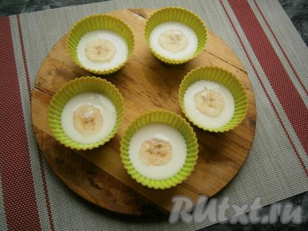 Творожно-желатиновую смесь разлить по силиконовым формочкам, заполняя их до половины, в середину поместить по кружочку банана.