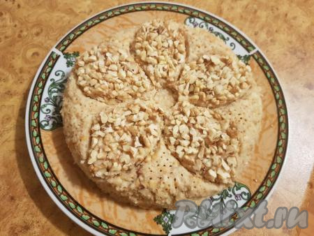 Заполнить контур цветка кусочками грецких орехов. На той части торта, которая не посыпана грецкими орехами, зубочисткой сделать небольшие отверстия (как на фото).