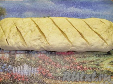 Делим тесто на две части. Из каждой части теста формируем хлеб в виде батона. Делаем острым ножом диагональные надрезы глубиной около 1 см.