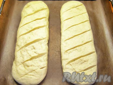 Противень застилаем пекарской бумагой (или силиконовым ковриком для выпечки) и выкладываем на него заготовки хлеба&nbsp;на расстоянии 5-7 см друг от друга. Оставляем для расстойки минут на 20, прикрыв тесто полотенцем. В это время можно прогреть духовку до 190-200 градусов.