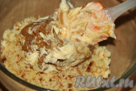 Смесь сгущёнки и масла добавить в бисквитную крошку, перемешать до однородного состояния.