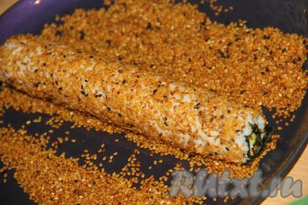 Кунжут высыпать на плоскую тарелку и обвалять получившийся ролл в кунжуте.