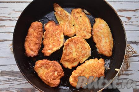 Через 5-7 минут лопаткой (или вилкой) переверните кусочки куриного филе в сырном кляре на другую сторону, жарьте ещё 4-5 минут на слабом огне, накрыв сковороду крышкой.