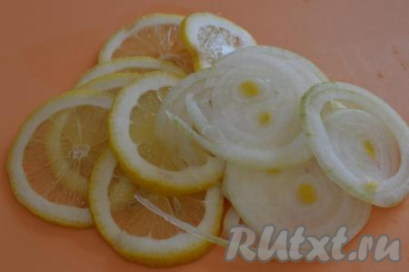 Оставшуюся часть лимона нарезать на тонкие кружочки. Репчатый лук очистить, промыть и нарезать на тонкие кольца.
