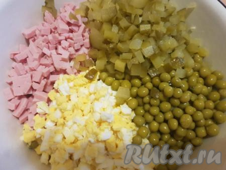 Консервированный горошек (без жидкости), нарезанные яйца, огурцы и варёную колбасу выложить в глубокую миску.