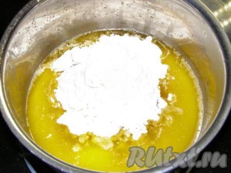 Убираем сотейник с огня, сразу добавляем муку и быстро перемешиваем ложкой до однородности.