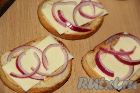 Поверх сыра разложить полукольца маринованного&nbsp;лука.