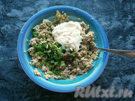 Теперь хорошенько желтки со шпротами размять той же вилкой, добавить соль и чёрный молотый перец по вкусу, нарезанный зелёный лук и майонез, перемешать начинку для фарширования яиц.