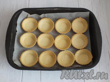 Включите духовку на 200 градусов. Возьмите форму (или противень), застелите пергаментом. Разложите тарталетки.