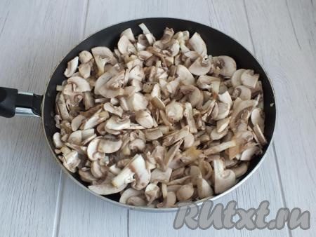 К обжаренному луку добавьте нарезанные грибы. Перемешайте, прибавьте огонь до чуть выше среднего и обжаривайте, помешивая.