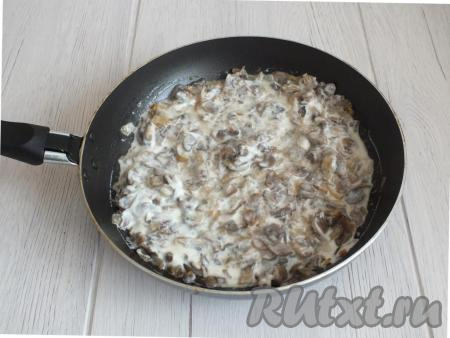 Не снимая с плиты сковороду, добавьте к грибам соль и чёрный молотый перец по вкусу, сметану, перемешайте и прогревайте в течение 5 минут, затем снимите с огня и дайте грибной начинке немного остыть.