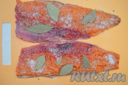 Посолить рыбу смесью соли, сахара и перца, сверху выложить лавровые листья, равномерно распределяя по всей длине рыбного филе.&nbsp;&nbsp;