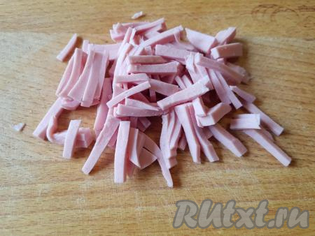 Нарезать варёную колбасу тонкой соломкой.