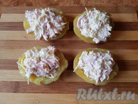 Выложить начинку в половинки картофеля.