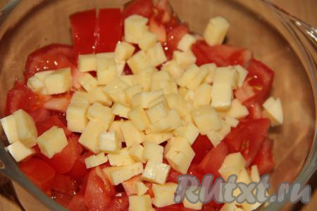 Сыр нарезать на мелкие кубики и добавить к помидорам.