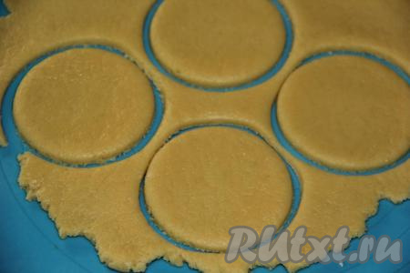 На столе, припылённом мукой (или на силиконовом коврике), тесто раскатать в пласт толщиной, примерно, 5 мм. Вырезать кружочки. Кружочки должны быть больше, чем диаметр абрикосов.