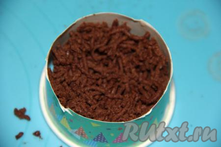 Для формирования печенья взять бумажный одноразовый стаканчик и отрезать верхушку шириной, примерно, 5 см. Небольшое количество теста отщипнуть от общей массы и пропустить через пресс (чеснокодавилку). Получившиеся макарончики выложить в бортики от стакана.&nbsp;