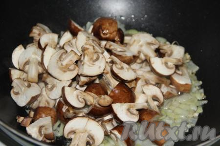 Обжарить лук, иногда перемешивая, в течение 2 минут на среднем огне. Грибы промыть водой, нарезать крупно и выложить в сковороду с обжаренным луком.
