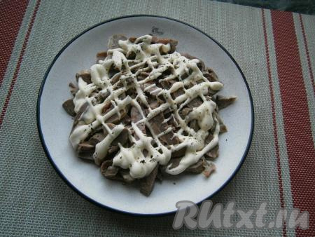 Выложить нарезанное сердце ровным слоем на плоскую тарелку, поперчить, если нужно, посолить немного, а затем нарисовать сеточку из майонеза.