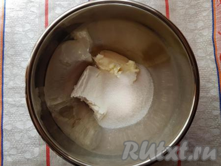 Для замешивания теста нужно в глубокую миску выложить творог и мягкое сливочное масло, насыпать сахар.