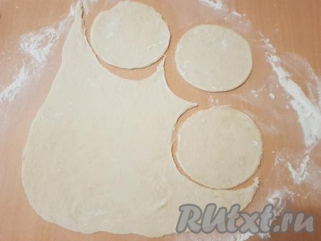 Далее подошедшее тесто разделить на 3-4 части. На столе, присыпанном мукой, с помощью скалки достаточно тонко раскатать каждую часть теста. Из раскатанного теста выдавить формой (я использовала форму диаметром 11,5 см) или стаканом кружочки. У меня получилось 24 кружочка диаметром 11,5 см.