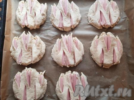 Противень застелить пергаментом. Места на пергаменте, на которые будут выкладываться булочки, смазать растительным маслом, затем выложить булочки.