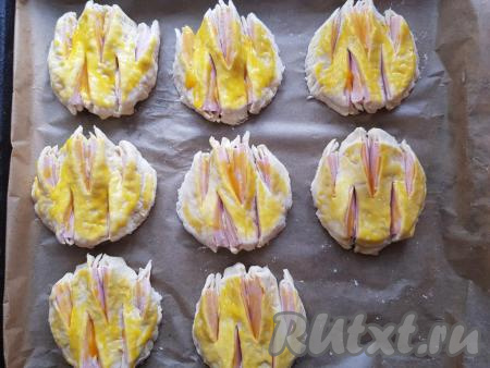 С помощью силиконовой кисточки сверху смазать булочки желтком и оставить их в тепле на минут 20.