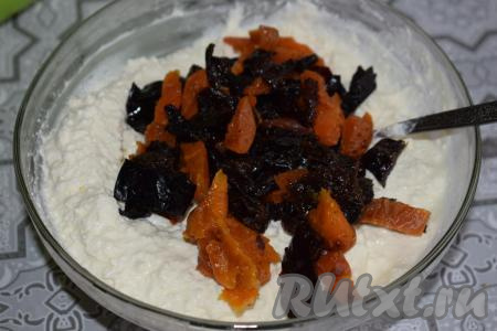 Сухофрукты промоем в горячей воде, сольем жидкость, дадим им обсохнуть. Подсушенные сухофрукты нарежем на кусочки и добавим их к творожной массе, перемешаем.