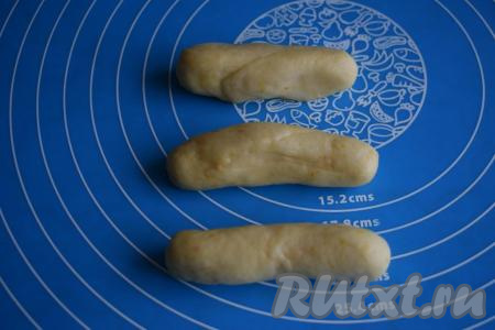 Обминаем каждый кусочек теста и подкатываем их в шарики. Каждый шарик раскатываем в колбаску.