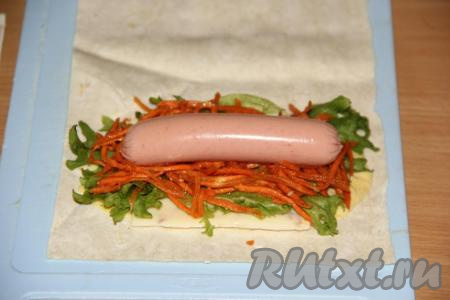 Затем выложить сосиску, предварительно очищенную от слюды.