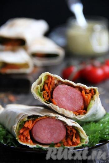 Очень вкусные, сытные сосиски в лаваше с морковкой по-корейски подать в тёплом виде. Такая аппетитная закуска понравится многим!