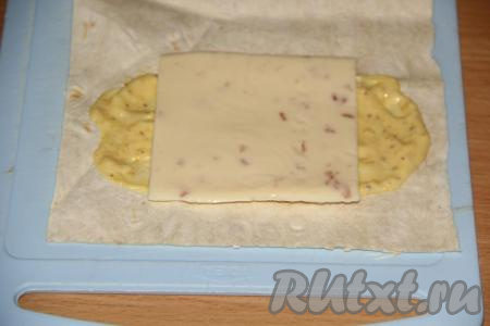 Выложить на соус пластинку плавленного сыра. Вместо плавленного сыра можно натереть на крупной тёрке любой твёрдый сыр.