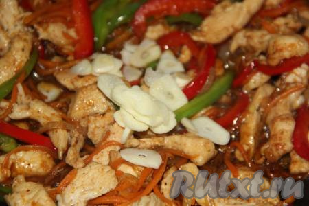 Чеснок очистить, нарезать тонкими лепестками и вместе с соевым соусом добавить в сковороду, перемешать.