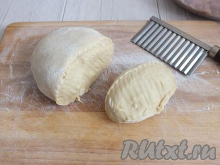 По истечении времени достаньте пельменное тесто из холодильника. Рабочую поверхность, руки и скалку натрите мукой. От теста отрежьте 1/4 часть.