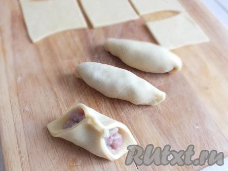 Соедините противоположные уголки заготовки пельменя (как на фото), далее соедините по шву. Между ладоней несколько раз прокрутите, придавая пельменю удлинённую форму.&nbsp;