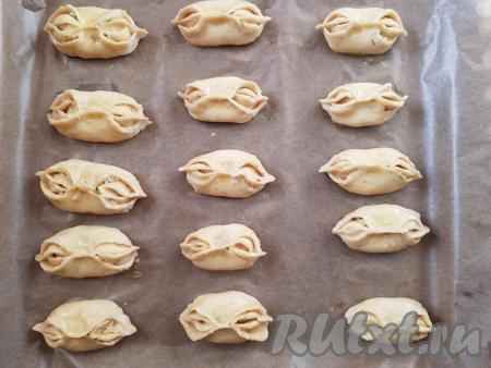 Застелить противень пергаментом. Места на пергаменте, на которые планируете выкладывать булочки, нужно смазать растительным маслом. На места, смазанные маслом, выложить булочки. Верх булочек с помощью силиконовой кисточки смазать яйцом и оставить минут на 20 в тепле.